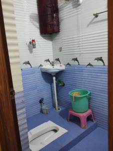 a bathroom with a sink and birds on the wall at Asha vihara Phase-2 in Muzaffarpur