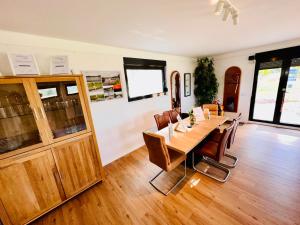 comedor con mesa de madera y sillas en Premium Ferienwohnung Ulf-Dieter Kunstmann, en Kremmen