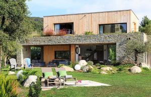 Casa de piedra con sillas verdes y patio en Les lofts de palombaggia, en Porto Vecchio