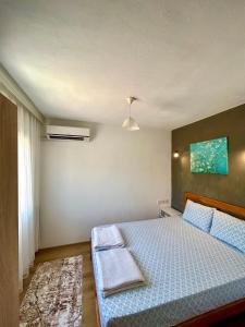 een slaapkamer met een bed met een blauw dekbed bij Begonvilli Ev in Bodrum City