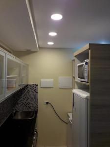 a small kitchen with a sink and a microwave at Apartamento na melhor localização de Recife in Recife