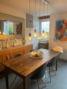 Maison de ville في تولوز: غرفة طعام مع طاولة وكراسي خشبية