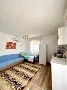 een woonkamer met een blauwe bank en een koelkast bij Begonvilli Ev in Bodrum City