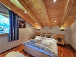 Aramis Penthouse في ساس في: غرفة نوم بسرير كبير وسقف خشبي