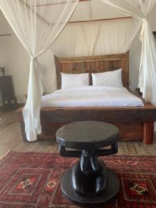 a bedroom with a bed with a table in it at Zi Loft Beach Cottage in Matemwe