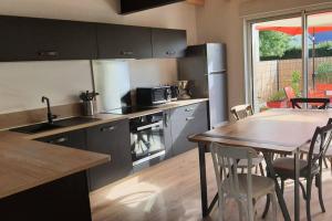 a kitchen with a table and a table and chairs at Gîte Sweetloire in La Menitré