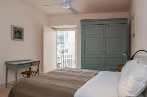 a bedroom with a bed and a desk and a window at Palazzo Degli Olivi in Modica