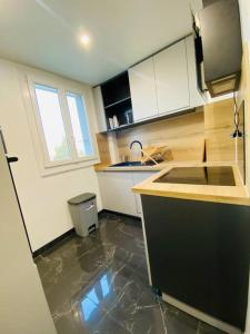 una cocina con encimera y fregadero. en Magnifique appartement de 4 chambres 8 personnes max à 20 minutes de Paris en Antony