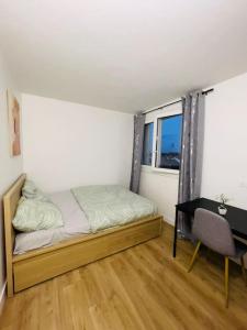 een kleine slaapkamer met een bed en een bureau bij Magnifique appartement de 4 chambres 8 personnes max à 20 minutes de Paris in Antony