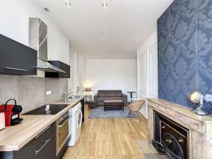 a kitchen with a stove top oven next to a living room at Cosy appt Part Dieu Félix 3 in Lyon