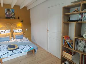 a bedroom with a bed and a book shelf at Tannerie 4 in Lanvallay