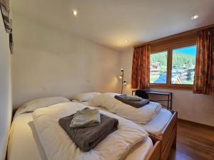two twin beds in a room with a window at Aramis Lodge in Saas-Fee