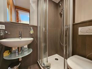 a bathroom with a sink and a shower at Aramis Lodge in Saas-Fee
