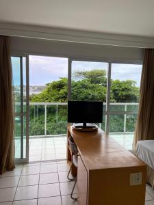 a room with a computer on a desk in front of a window at Praia do Canto Apart Hotel in Vitória