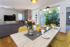 ein Esstisch mit einer Vase mit Blumen darauf in der Unterkunft LIFE - NEW and LUXURY holiday house in Kaštela