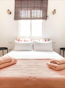 Un dormitorio con una cama grande con sábanas blancas y una ventana. en Casa Veronica 4 , 1 Dormotorio, en Arona