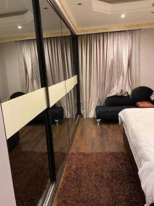 um quarto com um espelho, uma cama e um sofá em Maadi appartment no Cairo