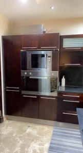 uma cozinha com armários de madeira e um micro-ondas em Maadi appartment no Cairo