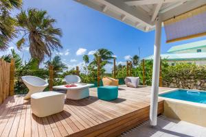 una terraza con sillas, una mesa y una piscina en Iguane House Villas & Micro Spa, en Sainte-Anne