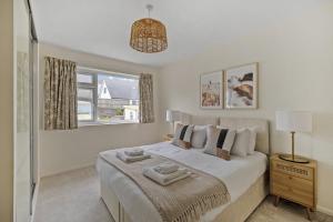 a white bedroom with a bed and a window at Modern Homely 3 bed in Central Plymouth w parking in Plymouth