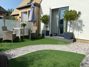 a garden with grass and a table and chairs at Dewcroft in Horsley
