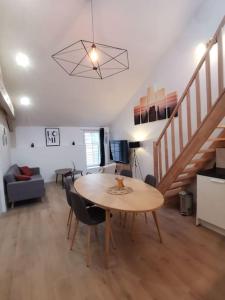 ein Wohnzimmer mit Tisch und Treppe in der Unterkunft 4 pièces centre-ville Bourg-en-Bresse in Bourg-en-Bresse