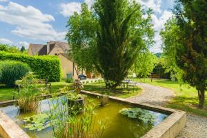 un jardin avec un étang au milieu dans l'établissement La Barde Montfort, votre maison d'hôtes à 4 kms de Sarlat Dordogne, à Vitrac
