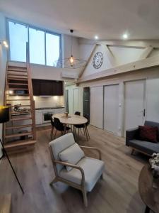 ein Wohnzimmer mit einem Tisch und einer Uhr an der Wand in der Unterkunft 4 pièces centre-ville Bourg-en-Bresse in Bourg-en-Bresse