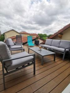 eine Terrasse mit Stühlen, einem Sofa und einem Tisch in der Unterkunft 4 pièces centre-ville Bourg-en-Bresse in Bourg-en-Bresse
