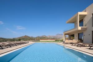 a villa with a swimming pool in front of a building at Casa Beleza Villa, a Mythical Retreat, By ThinkVilla in Perama