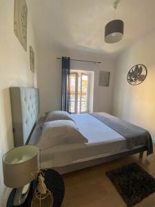 ein Schlafzimmer mit einem großen Bett und einem Fenster in der Unterkunft Appartement Biot Village in Biot