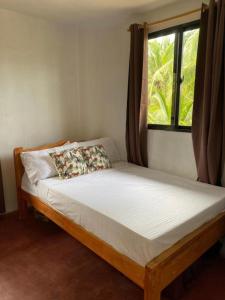 een bed in een kamer met een raam bij Beach House and Attic in Mahuyabhuyab