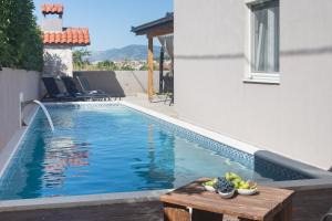 una piscina con tavolo accanto a un edificio di LIFE - NEW and LUXURY holiday house a Kaštela (Castelli)