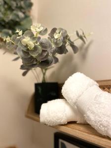 ręcznik na półce z wazonem kwiatów w obiekcie Stylish Apartment in Leafy Ealing w mieście Ealing