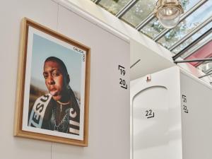 a framed picture of a rapper hanging on a wall at CityHub Amsterdam in Amsterdam