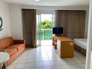 A television and/or entertainment centre at Praia do Canto Apart Hotel