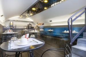 un restaurante con paredes azules, mesas y sillas en Libertel Montmartre Opéra, en París
