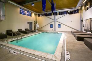 a large swimming pool in a building with couches at Aloft Birmingham Soho Square in Homewood