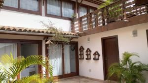 een huis met een houten deur en een balkon bij Local Brasil House in Morro de São Paulo