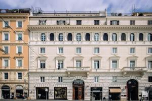 un grande edificio bianco con molte finestre di Hotel Boutique Nazionale a Roma