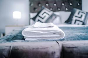 a stack of towels sitting on top of a bed at Home Away Apartment in Manchester