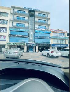 a parking lot with cars parked in front of a building at Luxury Private Top Floor Apartment in Heart of Bahria Town in Lahore