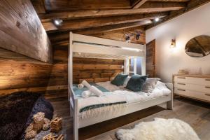 a bedroom with a bunk bed and a wooden wall at Silverstone by Alpine Residences in Val-d'Isère