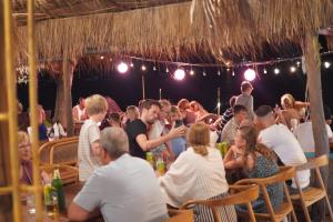 een groep mensen die aan tafel zitten in een restaurant bij Kirati Beach Resort in Choeng Mon Beach