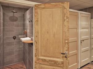 La salle de bains est pourvue d'une douche et d'une porte en bois. dans l'établissement CityHub Amsterdam, à Amsterdam