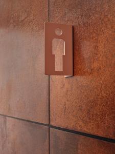 a sign on a brick wall with a key on it at CityHub Amsterdam in Amsterdam