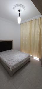 een slaapkamer met een bed in een kamer met een raam bij Dar zman in Kelibia