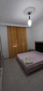 een slaapkamer met een bed in een kamer met een raam bij Dar zman in Kelibia