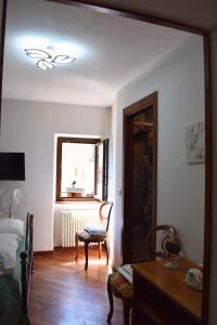 a bedroom with a bed and a chair and a window at IL GINEPRO B&B in Piamaggio