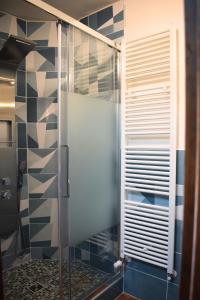 a shower with a glass door in a bathroom at IL GINEPRO B&B in Piamaggio